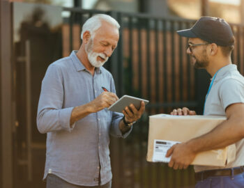 Happy mature man signing on digital tablet for a home delivery.